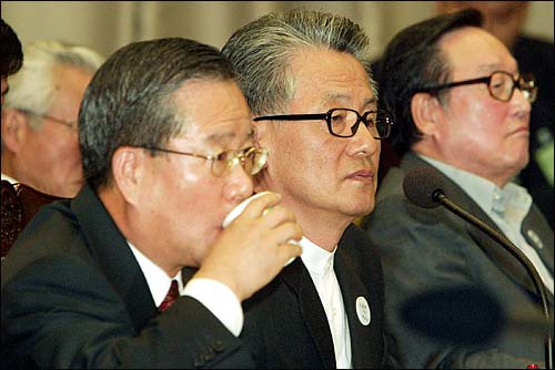 지난 2003년 10월 6일 국회 법사위 대검찰청 국정감사에서 증인으로 출석한 이익치 전 현대증권 회장(왼쪽)이 물을 마시고 있다. 